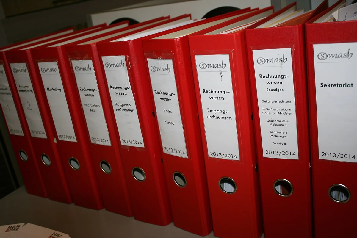 Dossiers administratifs alignés sur une étagère, illustrant les pièces à fournir pour un dossier de naturalisation française